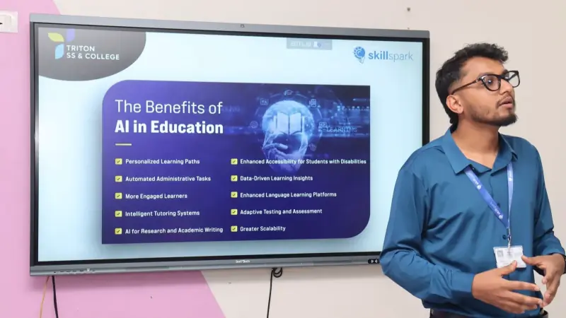 Speaker beside a wall-mounted display showing a slide titled "The Benefits of AI in Education".